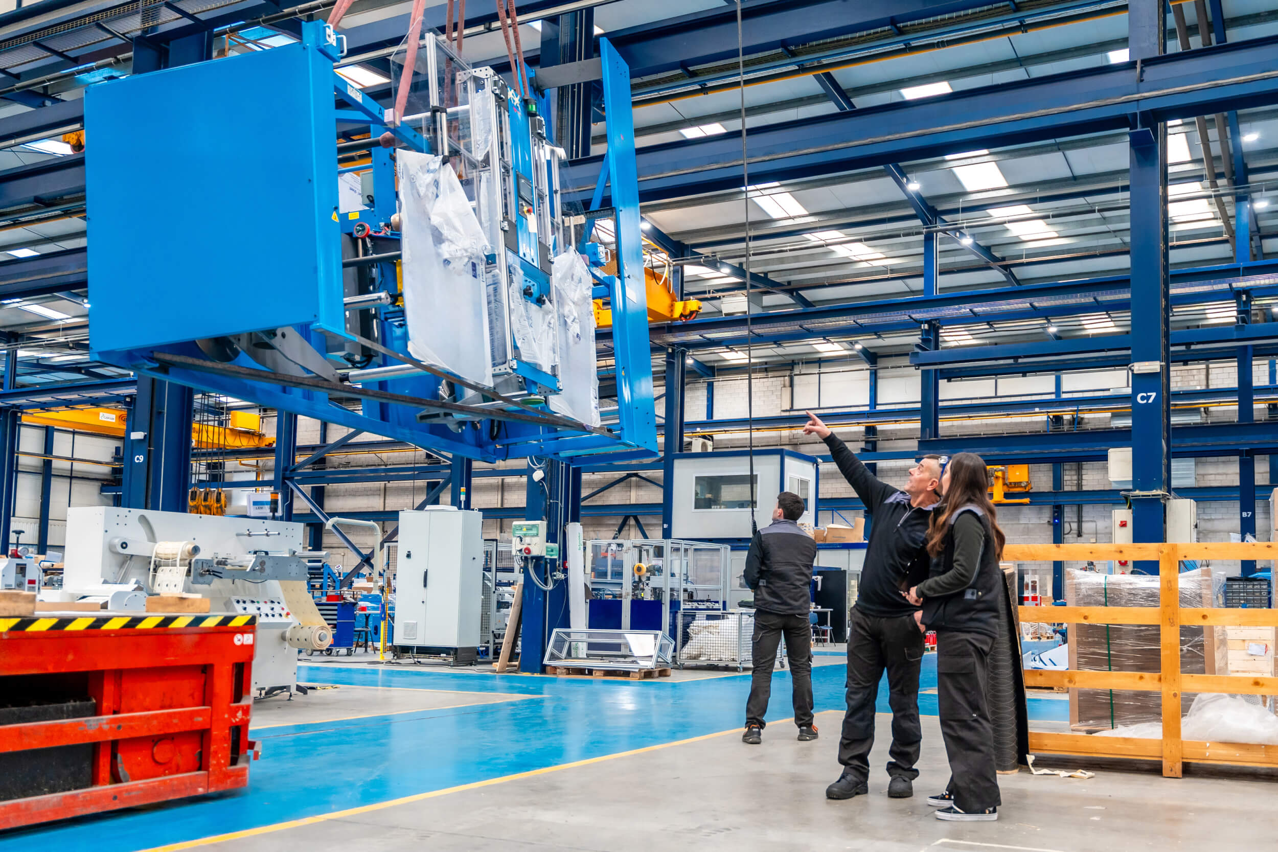 team-engineers-lifting-heavy-machinery-using-crane-(1)
